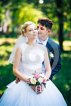 Portrait the bride and groom on the background of the park alley