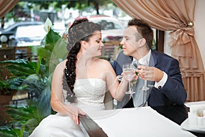 Portrait of bride and groom drinking champagne at luxury restaurant