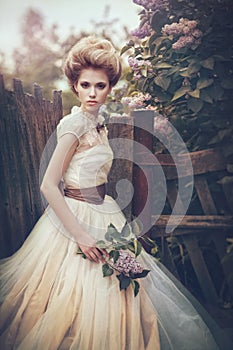 Portrait of a bride in a white dress with flowers in retro style.