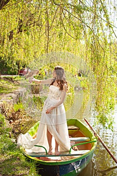 Portrait of bride in white wedding dress with barn owl on lake
