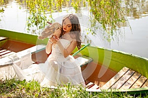Portrait of bride in white wedding dress with barn owl on lake