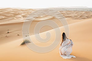 Portrait of bride woman in amazing wedding dress in Sahara desert dunes, Morocco