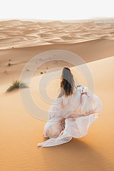 Portrait of bride woman in amazing wedding dress in Sahara desert dunes, Morocco