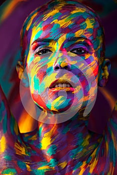 Portrait of the bright beautiful girl with brush, art colorful make-up face art and bodyart