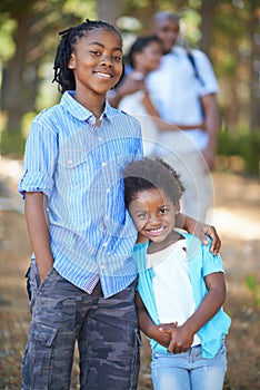 Portrait, brother and sister hiking in the forest together with their parents for travel, freedom or adventure. Black