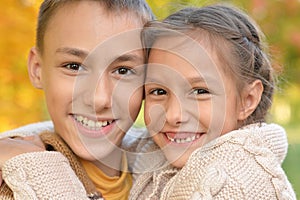 Portrait of brother and sister hugging in autumnal park