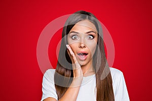 Portrait of brown-haired gorgeous nice amazed young lady showing shock with hand to cheek, opened mouth, over grey