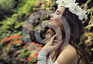 Portrait of a brunette beauty in a tropical garden