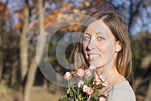 Portrait of a brunette girl holding miniature roses