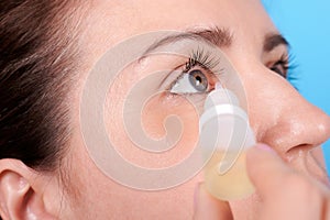 Portrait of a brunette girl using eyedrops