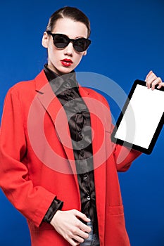 Portrait of a brunette in a jacket with a tablet in hand