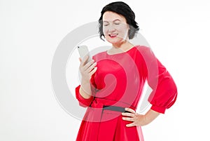 Portrait brunette in red dress having Ñhat text conversation and holding phone