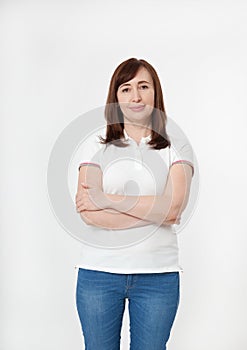 Portrait of brunette serious woman in blank white t-shirt and crossed arms on chest with copy space on white background. Mock up