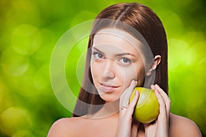 Portrait of brunette woman holding an apple on