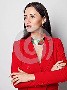 Portrait of brunette woman with permanent makeup in red jacket with deep neckline on naked body standing looking aside