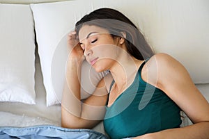 Portrait of brunette woman sleeping at home in bed on pillow