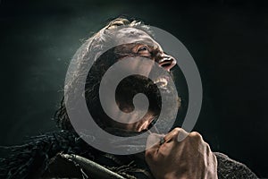 Portrait of a brutal bald-headed viking in a battle mail posing against a black background.