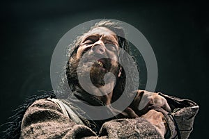 Portrait of a brutal bald-headed viking in a battle mail posing against a black background.
