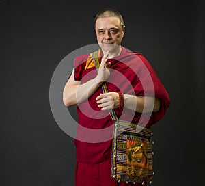 Portrait of a Buddhist monk in a red kesa robe with ritual attributes