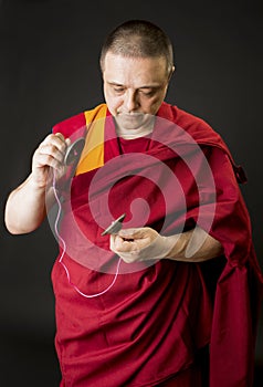 Portrait of a Buddhist monk in a red kesa robe with ritual attributes