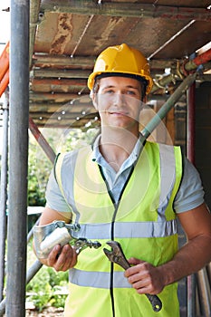 Portrait Of Builder Putting Up Scaffolding