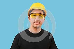 Portrait of a builder or worker in a helmet on a blue background. Building, teamwork