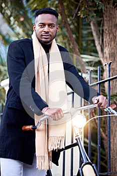 Portrait, business and black man with bicycle for travel, eco friendly transport or agent cycling to commute. Serious