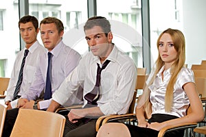 Portrait of business executives sitting in row at office