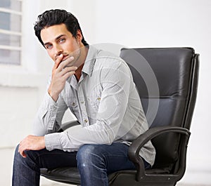 Portrait, business or man on chair in office thinking with pride for career, job or work. Professional, male