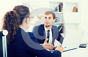 Portrait of business man sitting with computer in office on wor