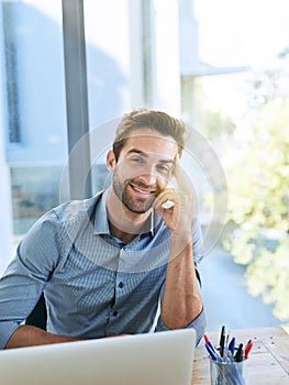 Portrait, business man and smile with laptop in desk at office in startup company as legal advisor. Entrepreneur, table