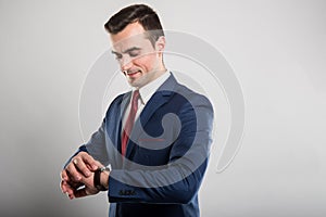 Portrait of business man wearing suit checking wrist watch