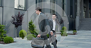 Portrait business partners meeting together at street. Successful businessmen shaking hands outdoors. Two business man