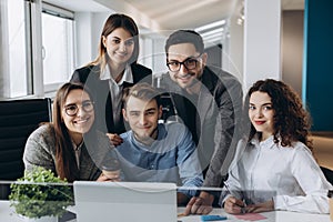 Portrait of business team working together in modern open space office startup. Looking at camera