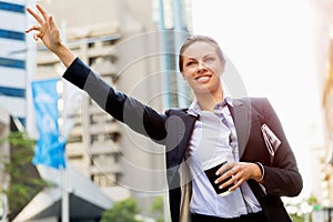 Portrait of business woman catching taxi