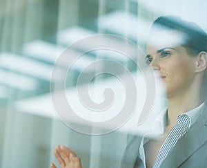 Portrait of business woman looking in window