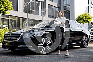 Portrait of business woman near a luxury car outdoors