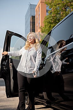 Portrait of business woman near minivan taxi