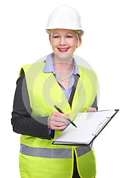 Portrait of a business woman in safety vest and hardhat writing on blank clipboard