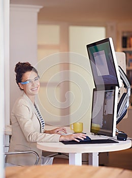 Portrait, business woman and smart glasses by computer at table in startup office. Smile, professional and creative