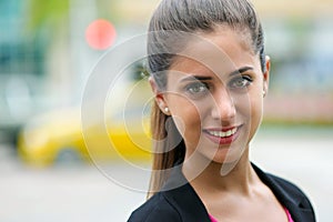 Portrait of business woman on street with cars and traffic light