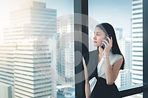Portrait of Business Woman is Talking on Mobile Phone in Her Office., Beautiful of  Asian Woman is Calling to Someone on Her Cell