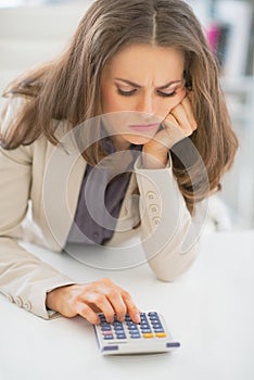 Portrait of business woman using calculator