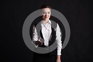 Portrait of a business woman who gives a hand for a handshake in the studio on a black background.