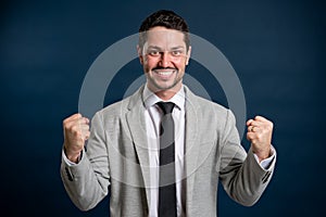 Portrait of business young handsome male making winning gesture