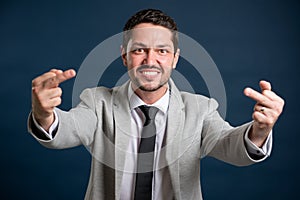 Portrait of business young handsome male showing double obscene gesture