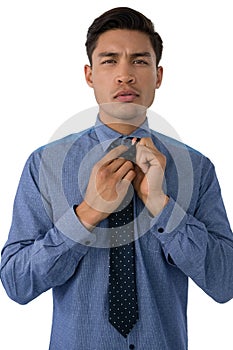 Portrait of businessman adjusting necktie