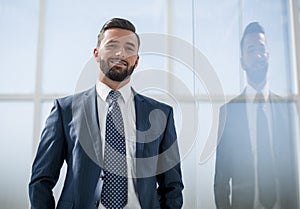 Portrait of a businessman on the background of an office window