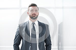 Portrait of a businessman on the background of an office window