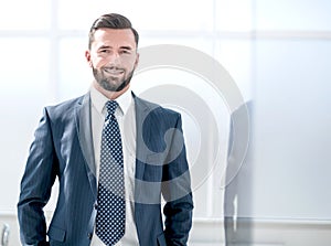 Portrait of a businessman on the background of an office window